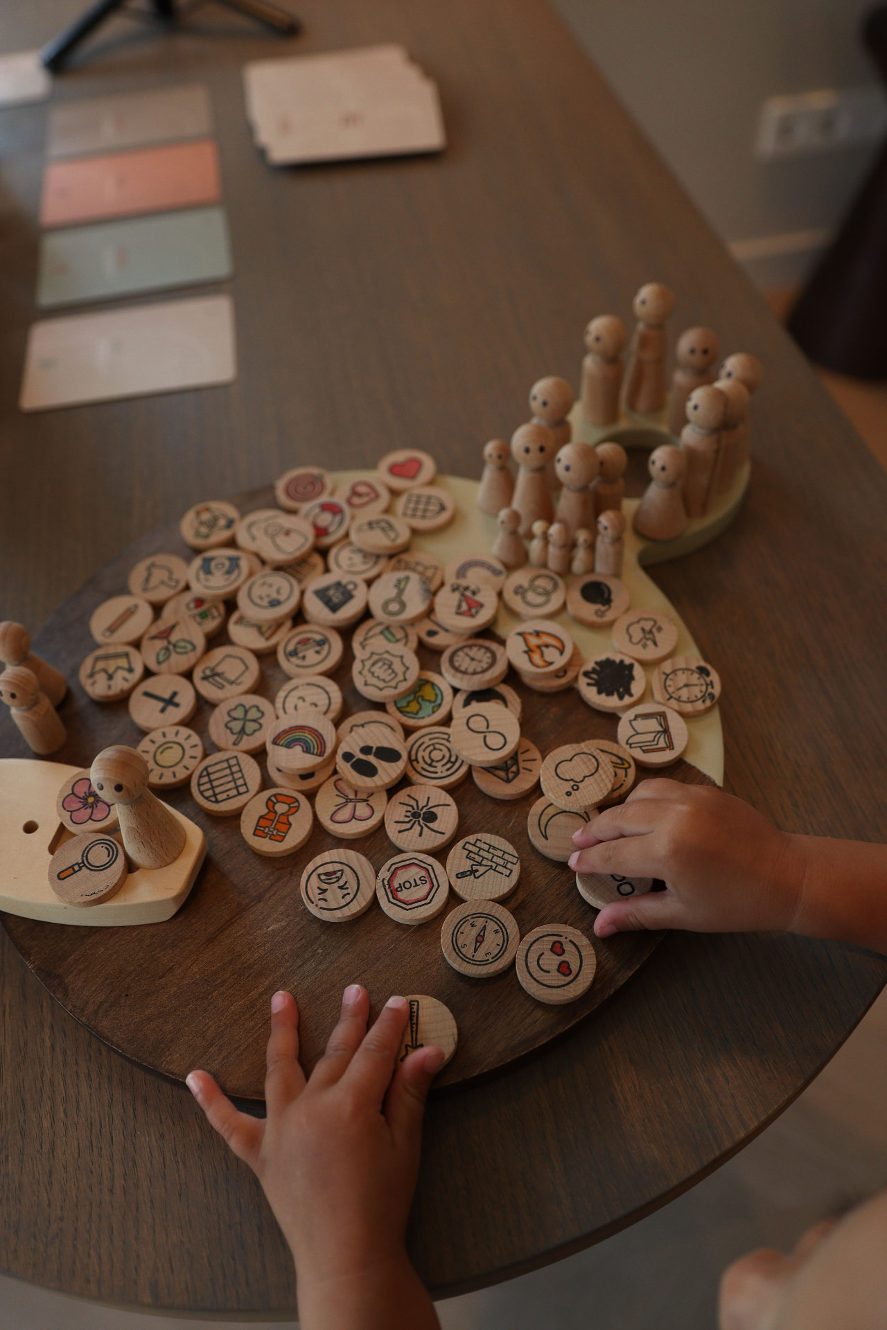 Kinderhanden bij houten poppetjes en symbolen op tafel
