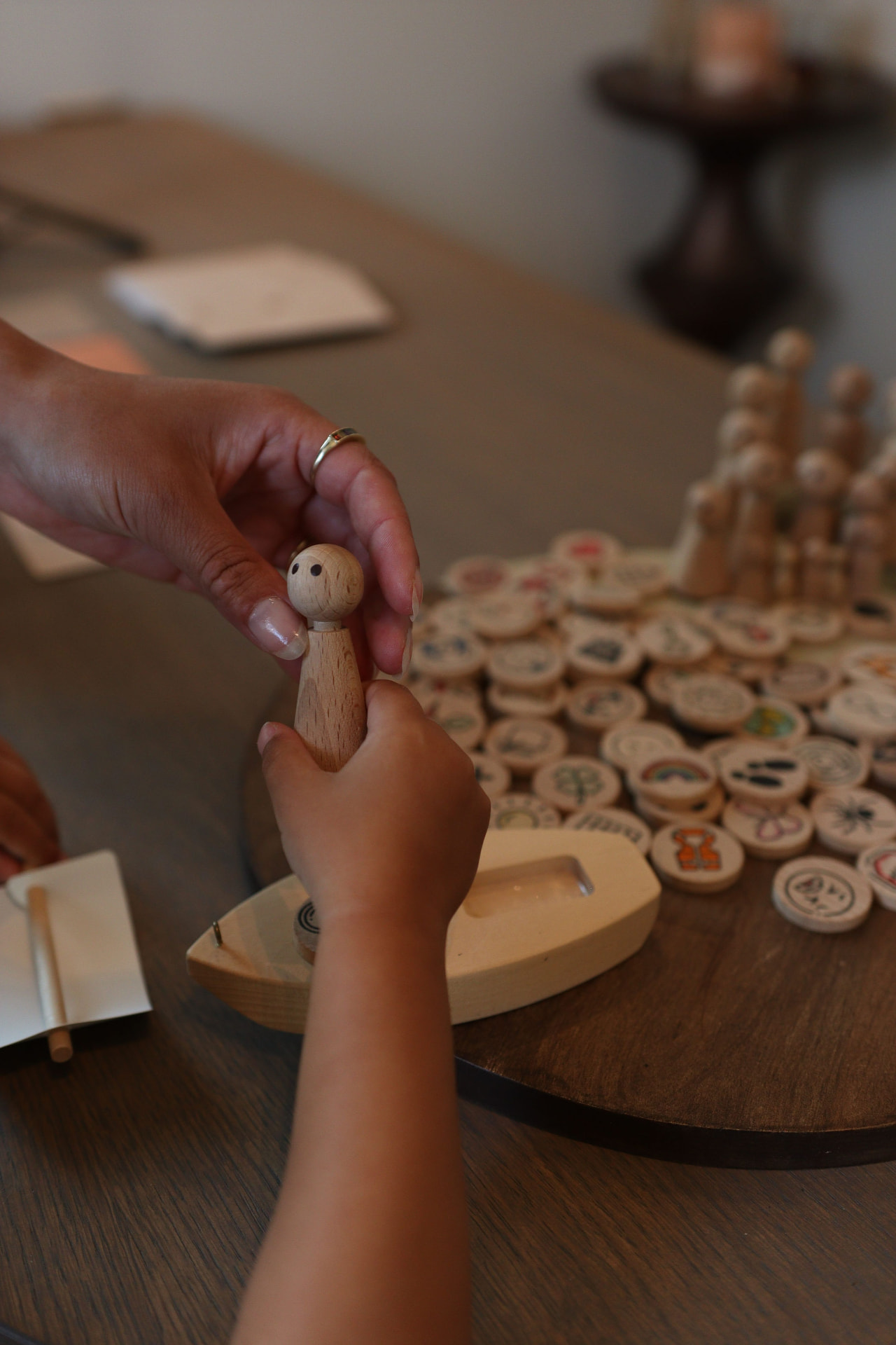 Hand van een volwassene en een kinderhand met een houten poppetje